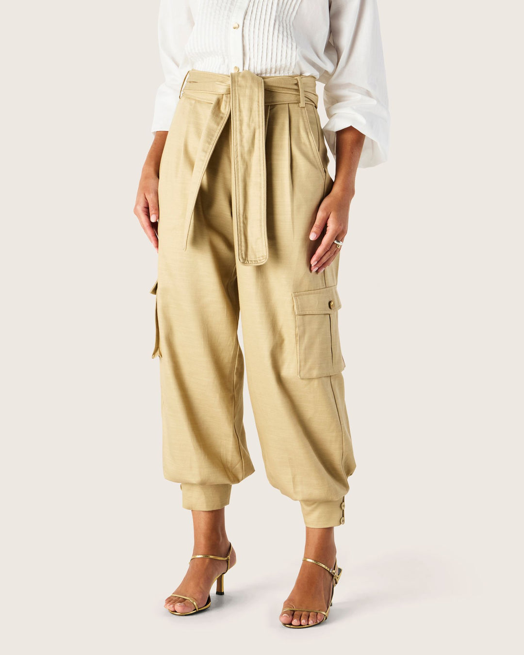 Beige cargo pants worn by a person on a white background